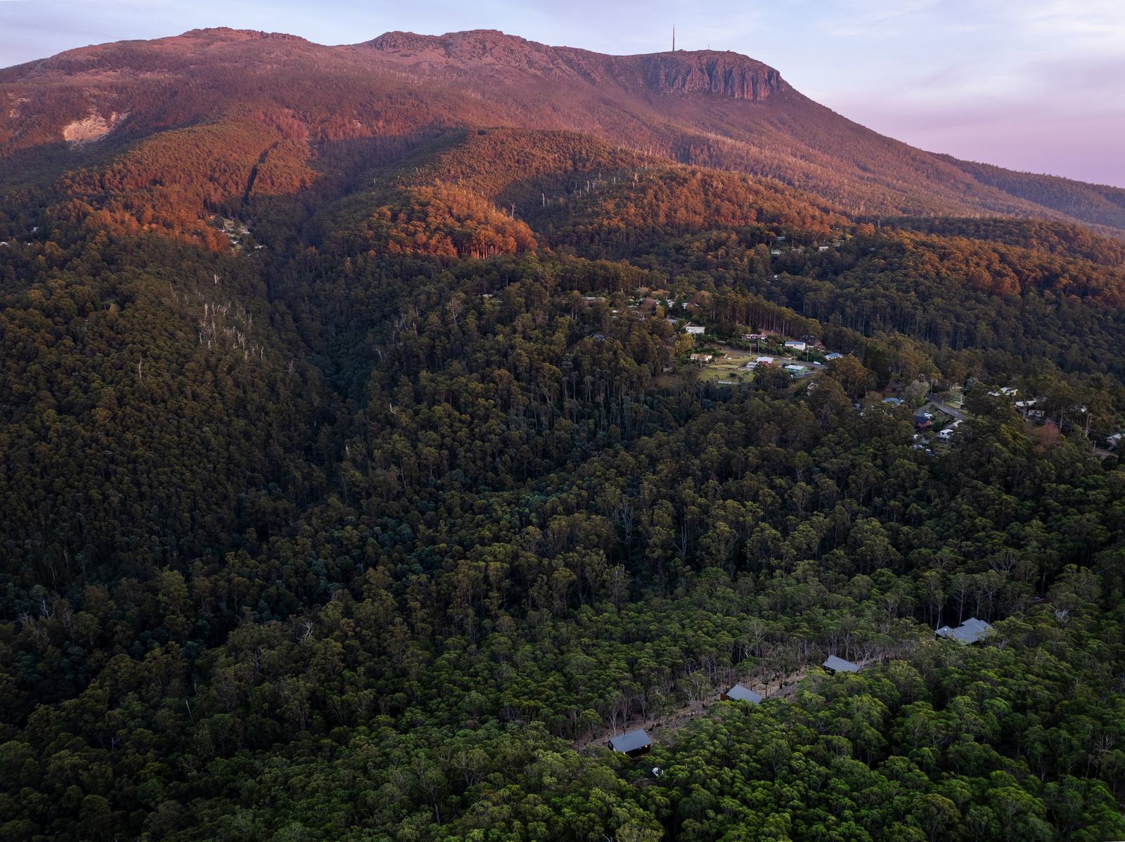 Aerial view of the Breath cabins nestled in the forest below kunanyi/Mount Wellington.