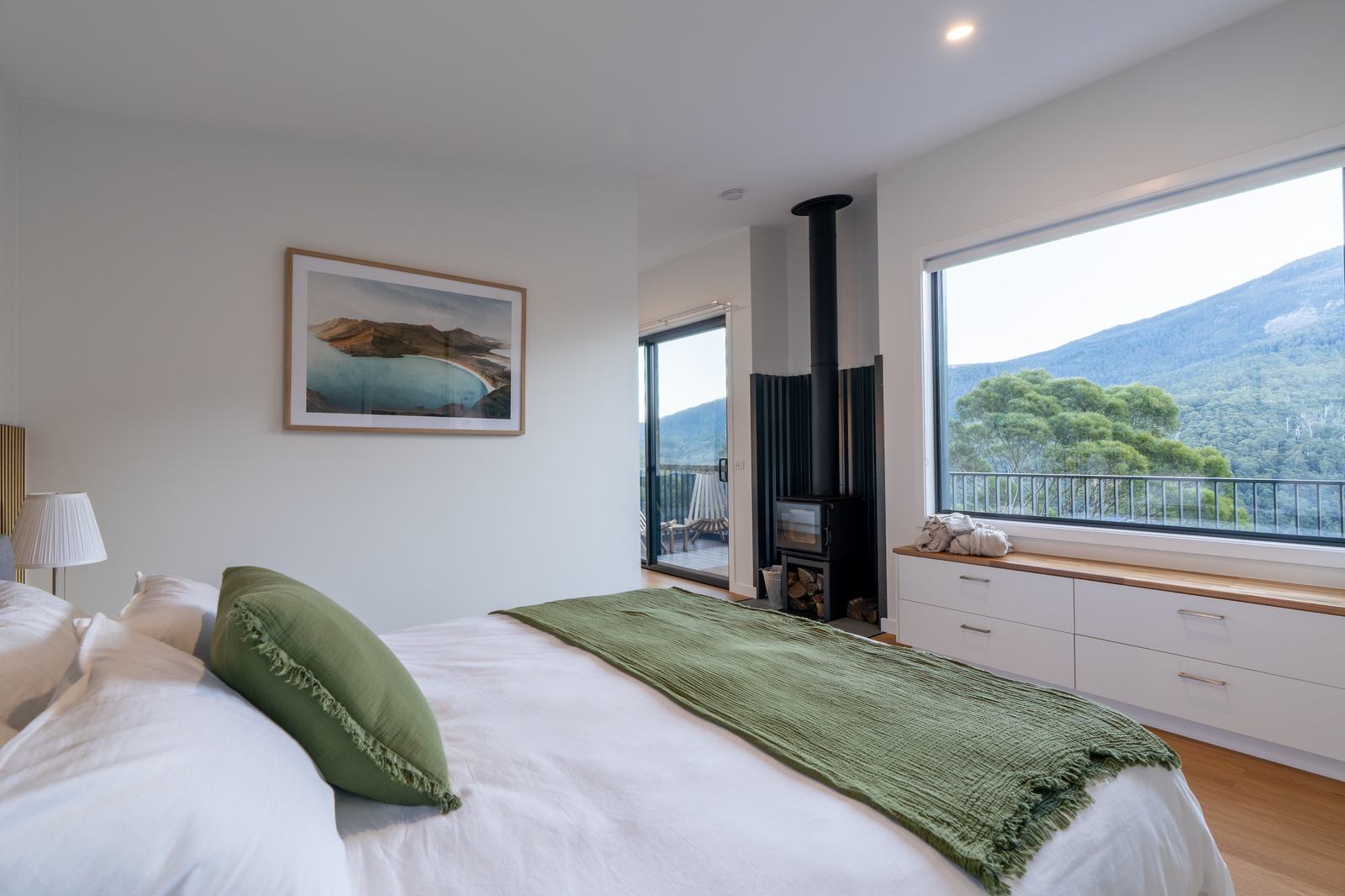 Comfortable bed looking out to views of mountain and forest