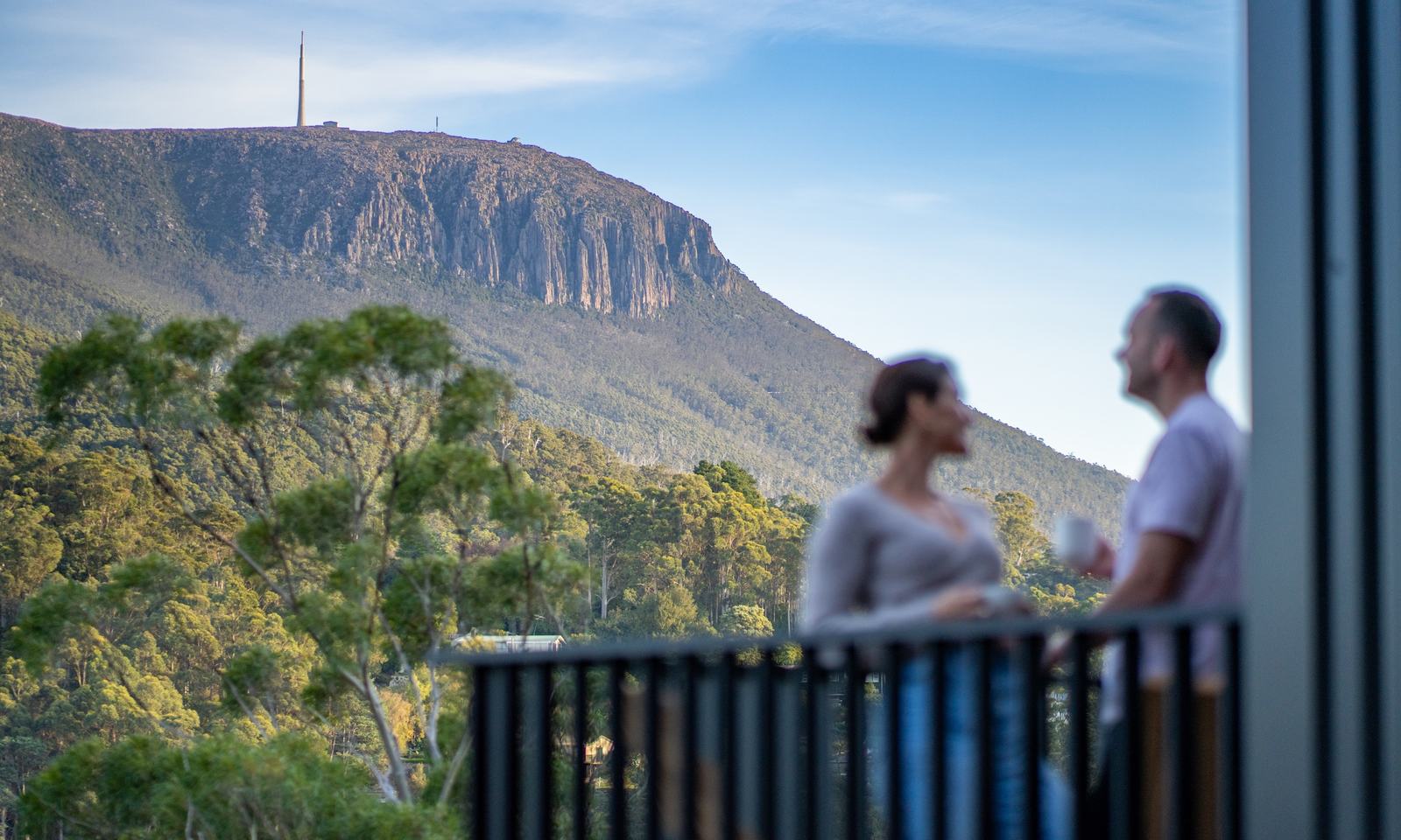 People standing on deck talking, with clear view of kunanyi mt wellington