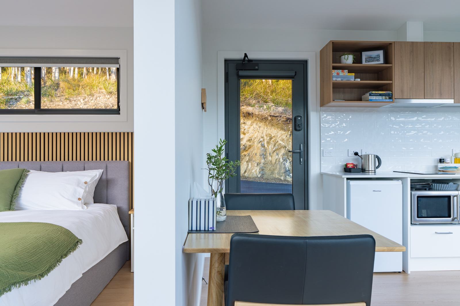 Split view of stillwater cabin showing bedroom and kitchen with partial dividing wall